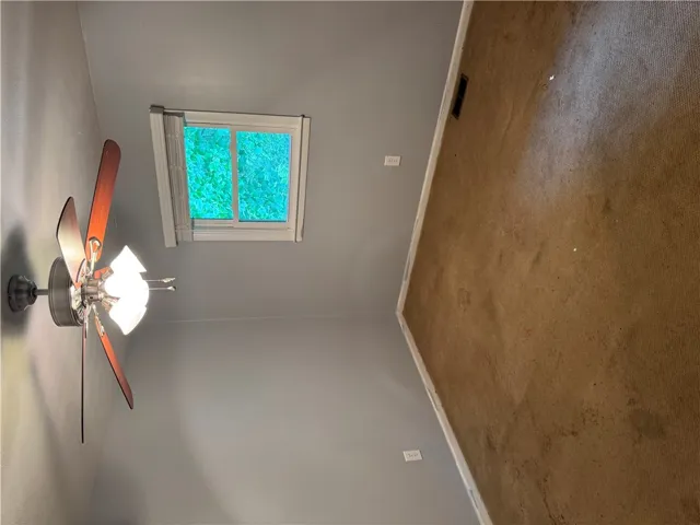 Overhead, a window offers natural light, complementing the warmth of the carpeted floor.