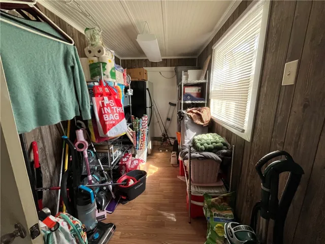 This storage room features durable wood paneling and a practical window for natural light.