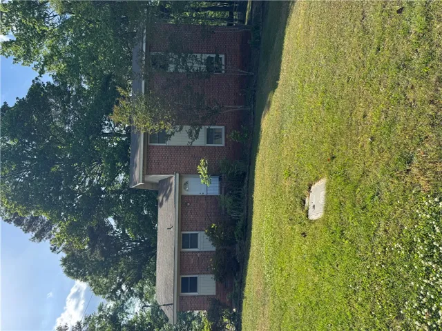 This classic brick residence is nestled in a verdant setting, offering a peaceful retreat.