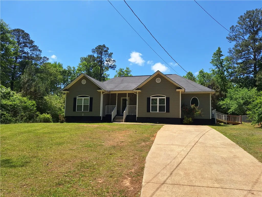 This charming home offers a welcoming facade with a classic porch and mature landscaping.