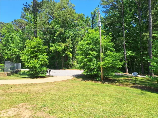 Lush green landscape surrounds this serene property, offering a private and expansive natural setting.