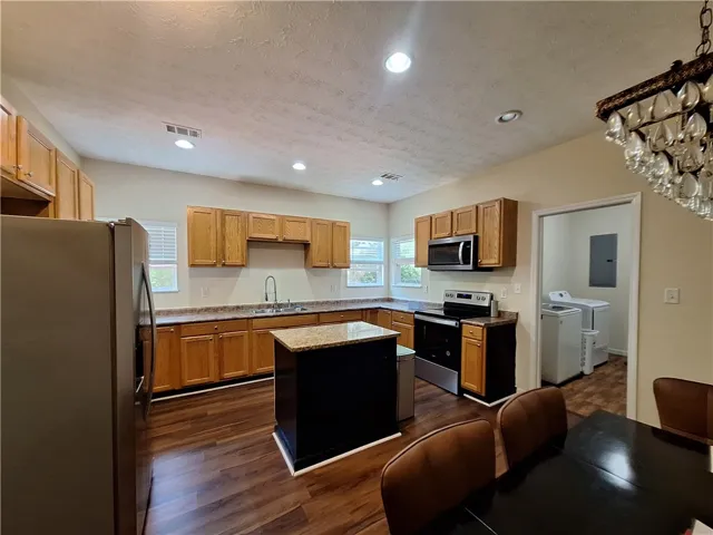 This spacious kitchen offers ample cabinetry, modern appliances, and a convenient central island.