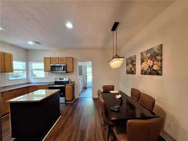 This open concept kitchen and dining area features rich wood flooring and abundant natural light.