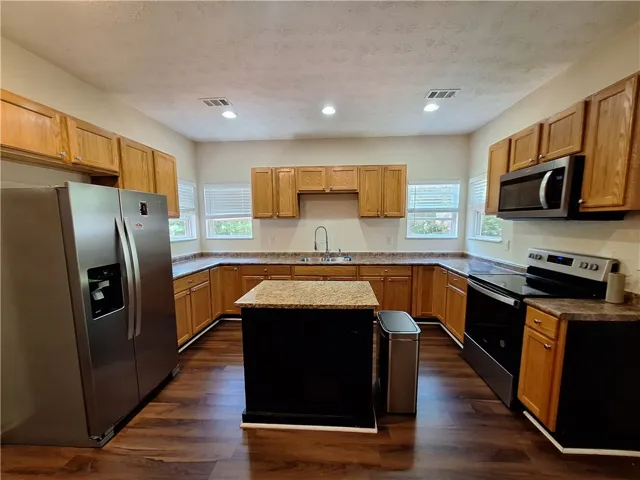 This spacious kitchen offers ample cabinetry and counter space, perfect for culinary endeavors.