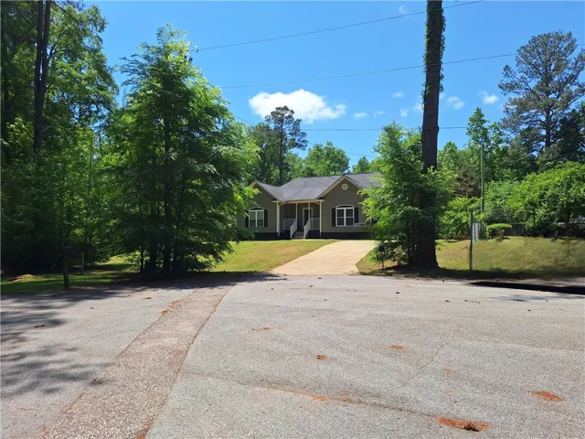 This charming home features a welcoming entrance and ample green space, perfect for outdoor enjoyment.