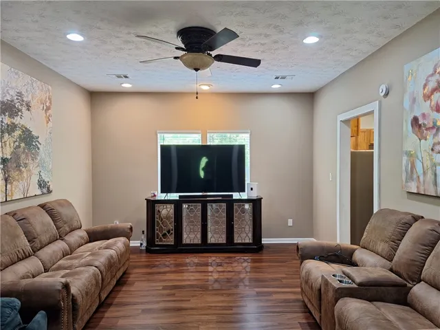 This inviting living area boasts rich wood flooring and practical recessed lighting.