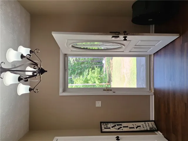 The inviting entryway features a decorative glass door, offering a glimpse of the verdant outdoors.