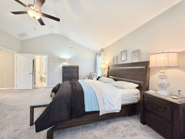 This spacious bedroom features vaulted ceilings and plush carpeting, offering a peaceful retreat.