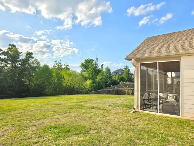 This spacious yard offers ample outdoor living space with a charming screened porch.