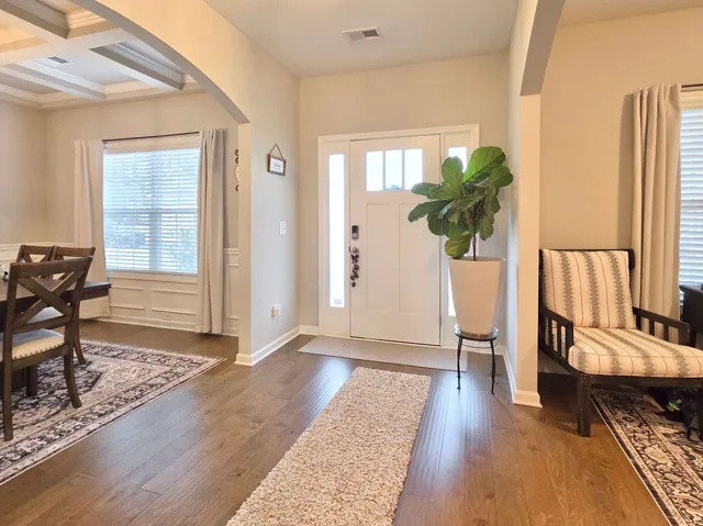 The bright foyer features warm wood flooring and welcomes you into the home's inviting living spaces.