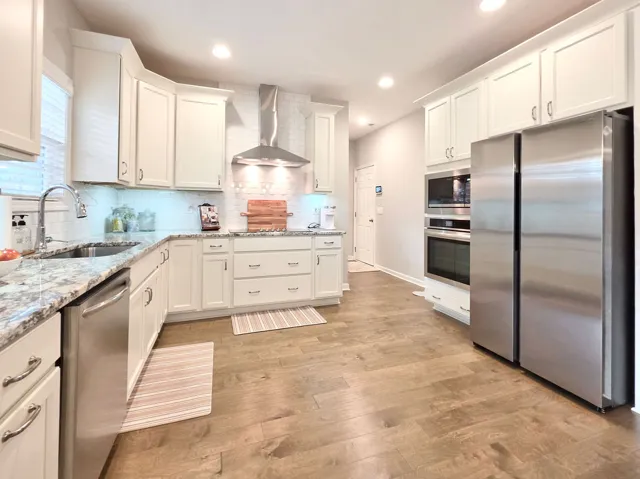 This bright kitchen features wood flooring and stainless steel appliances.