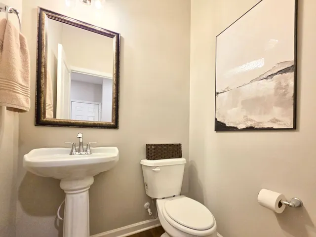 Powder Room features a pedestal sink and simple fixtures for everyday convenience.