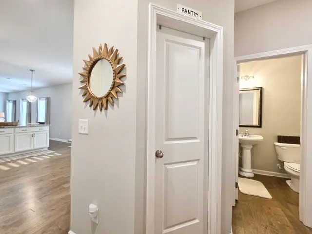 This interior showcases wood flooring, a convenient pantry, and a well-appointed powder room.