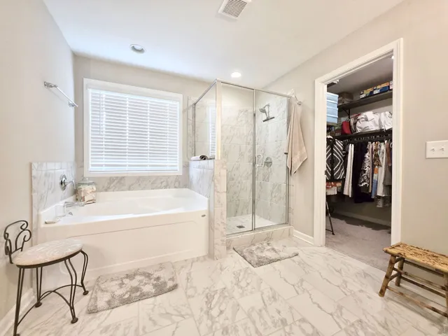 This spacious bathroom offers a relaxing soaking tub and a walk-in shower with direct access to 2 walk-in closets.