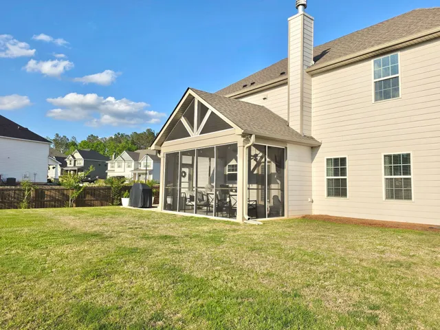 This spacious backyard features a charming screened porch, perfect for enjoying the outdoors.