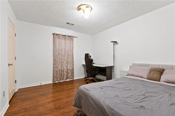 This spacious bedroom features warm hardwood floors and double closets, offering a versatile living space.