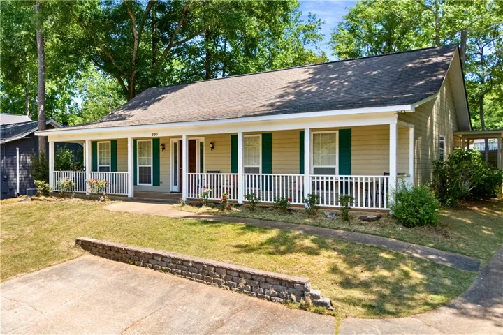 This charming home offers a welcoming facade with a covered porch and traditional shutters.