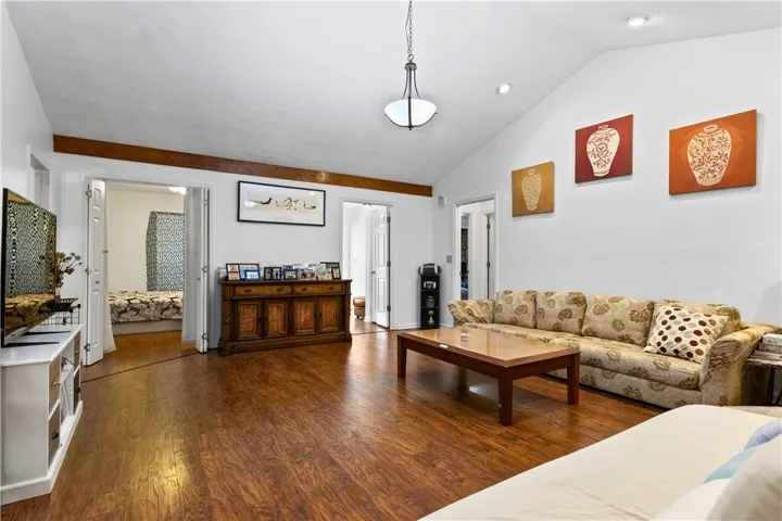 This inviting living area boasts rich hardwood flooring and vaulted ceilings, creating an airy ambiance.