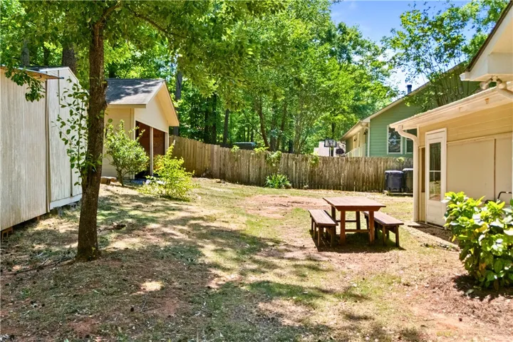 This yard features ample outdoor space with a shed, a detached open garage, and picnic area for relaxation.