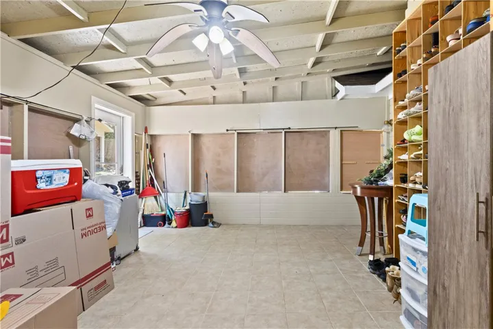 This spacious enclosed porch features exposed ceiling beams and a practical tiled floor.