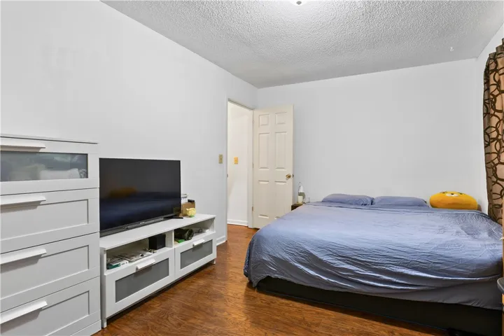 This cozy bedroom features durable hardwood flooring and a classic paneled door.