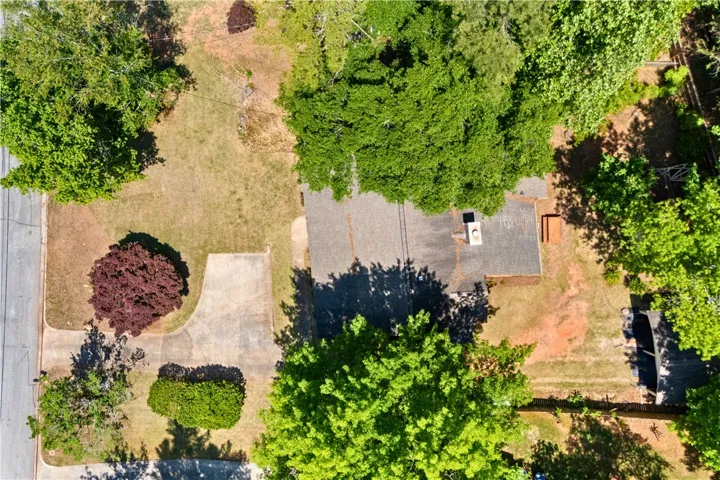 This property features mature trees and a private yard with a driveway, offering serene outdoor living.