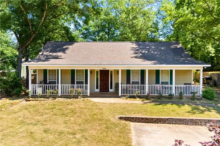 This charming home offers a welcoming facade with a covered porch and traditional shutters.