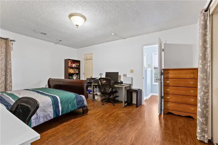 This spacious master bedroom offers ample natural light and durable flooring, perfect for relaxation and everyday living.