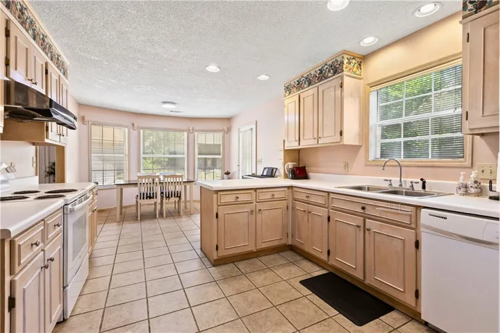 This spacious kitchen offers a delightful cooking and dining experience with ample natural light.