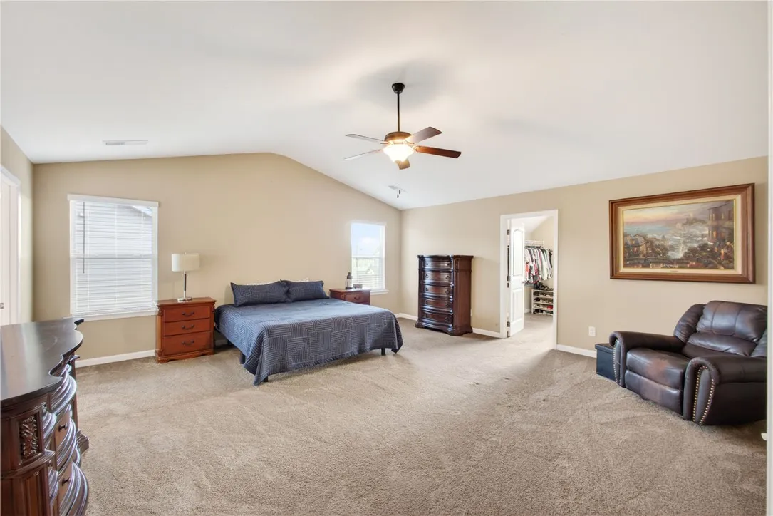 This spacious primary bedroom offers comfort with soft carpeting and ample natural light.