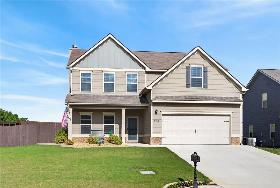This two-story residence presents a classic facade with a welcoming porch and attached garage.