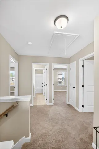 This bright hallway connects multiple rooms with warm, inviting carpet.