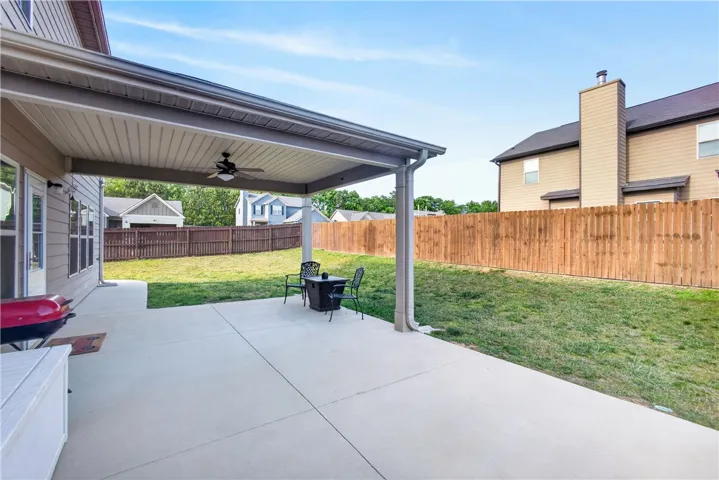 This outdoor space features a covered patio perfect for relaxation and entertaining, with a private fenced yard.