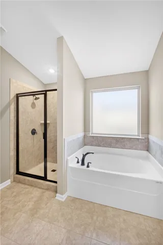 This spacious bathroom offers a relaxing soaking tub and a separate shower.