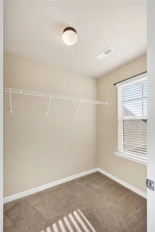 This organized walk-in closet offers efficient storage solutions and natural light.