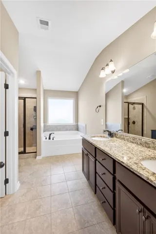 This spacious primary bathroom features a large soaking tub and a generous vanity with dual sinks.