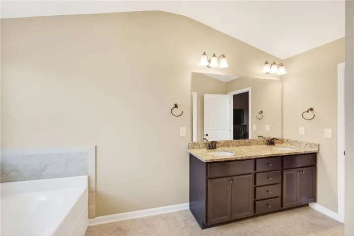This bathroom features a double vanity and tub, creating a luxurious and functional space.
