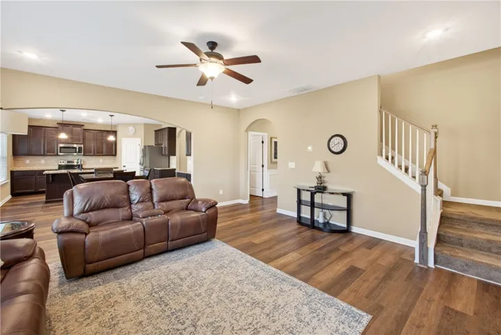 This inviting space features an open layout connecting the living area with a contemporary kitchen and convenient staircase access.