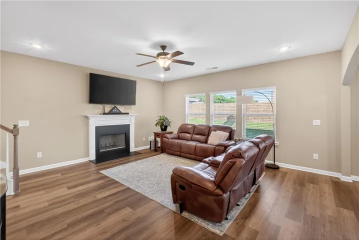This inviting great room boasts warm flooring, a cozy fireplace, and abundant natural light.