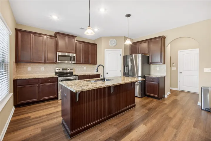 This functional kitchen features rich cabinetry, providing ample storage and a central island with a sink.