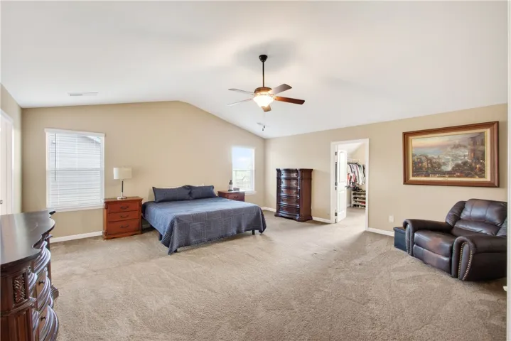 This spacious primary bedroom offers comfort with soft carpeting and ample natural light.