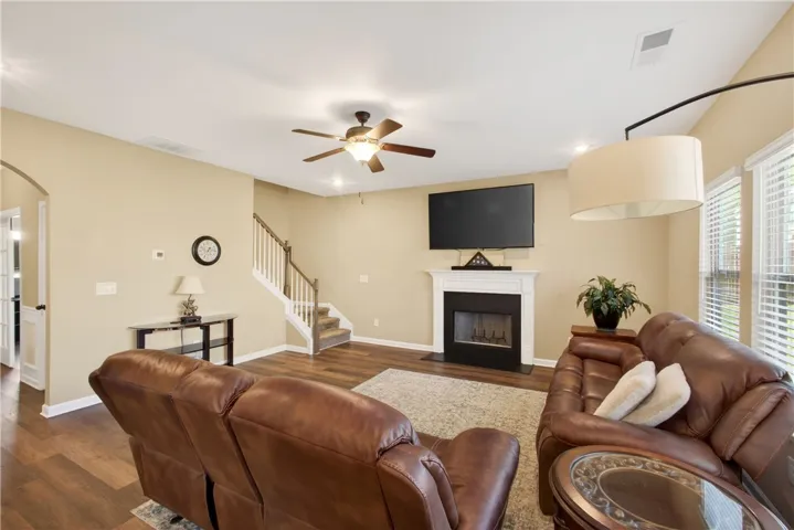 This inviting great room features a fireplace, ceiling fan, and recessed lighting for comfortable gatherings.