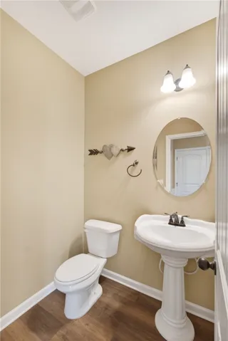 This bright bathroom features a pedestal sink, offering a clean and simple design.