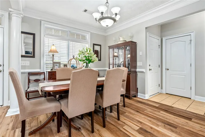 This bright dining room features rich wood flooring and classic crown molding, perfect for memorable gatherings.