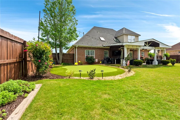 This residence features a lush lawn and a private putting green, perfect for outdoor enjoyment.