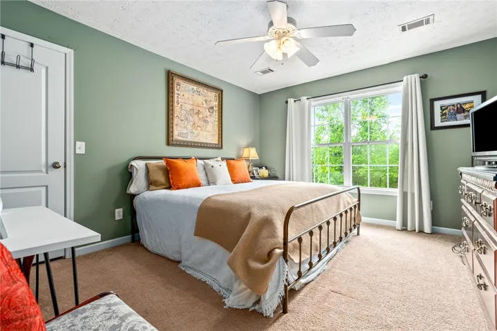 This tranquil bedroom features plush carpeting and a large window