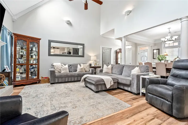 This airy living space features soaring ceilings and elegant wood flooring, perfect for gatherings.