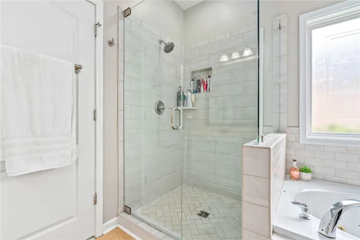 The primary bathroom includes a spacious walk-in shower and a large soaking tub.