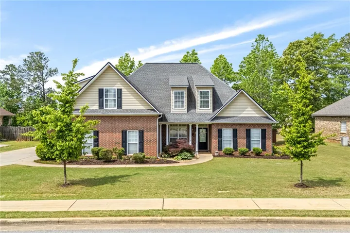 This charming residence features a classic brick and siding exterior with mature landscaping.