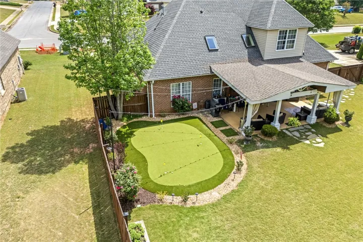 This spacious backyard features a dedicated putting green and a large covered patio for seamless outdoor living.